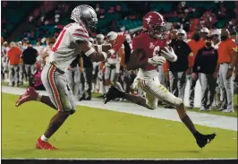  ?? CHRIS O’MEARA — THE ASSOCIATED PRESS ?? Alabama’s DeVonta Smith, right, was named Offensive Player of the Game on Monday night against Ohio State after catching 12 passes for 215 yards and three touchdowns.