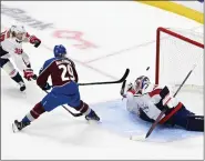  ?? ANDY CROSS — THE DENVER POST ?? Avalanche center Nathan Mackinnon scores a goal against Capitals goaltender Charlie Lindgren while defenseman Rasmus Sandin tries to defend in the second period, his third goal of the game, at Ball Arena in Denver on Wednesday.