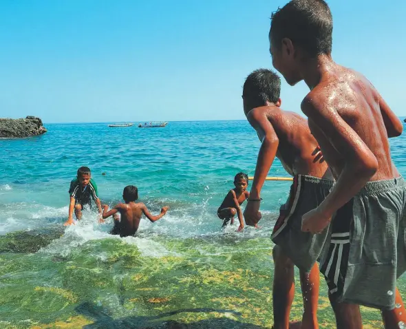  ??  ?? The next generation of lamafas play on Lamalera Beach.