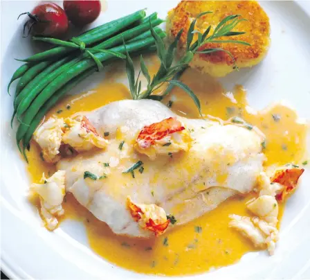  ?? ERIC AKIS ?? Roasted ling cod in lobster sauce is served with steamed green beans, sautéed cherry tomatoes and potato cakes.