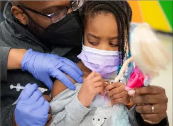  ?? Emily Matthews/Post-Gazette ?? Ariyona Coleman, 5, of Crafton, watches as she receives her first dose of the Pfizer COVID19 vaccine from Lynne Oncea, a nurse with UPMC, while her father, Antawn Coleman, also of Crafton, tries to distract her with a doll on Jan. 8 in the cafeteria at Pittsburgh Langley K8 in Sheraden.