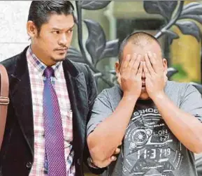  ?? PIC BY ABD RAHIM RAHMAT ?? A MACC officer escorting the suspect to the magistrate’s court in Putrajaya yesterday.