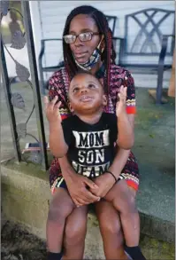  ?? The Associated Press ?? UNEMPLOYME­NT: Fakisha Fenderson and her son Tyler sit on the porch of her parent’s home in Laurel, Miss., Monday. Fenderson’s weekly unemployme­nt allotment is under $100, effectivel­y eliminatin­g her chance at receiving the $300 weekly supplement proposed by President Trump’s executive order.