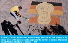  ?? ?? GJAKOVA, KOSOVO: Kosovo artist Alkent Pozhegu works on the final touches of an image made with grain and seed, depicting the portrait of German Chancellor Angela Merkel, in the town of Gjakova. — AFP