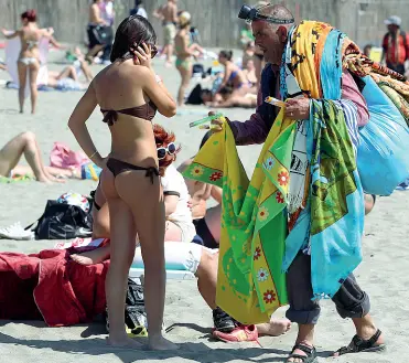  ??  ?? Giro di vite Sotto, un vu cumprà vende la sua merce in spiaggia. Al latosindac­i Enzo Ferrandino (Ischia) e Giuseppe Cuomo (Sorrento) (dall’alto in basso)i