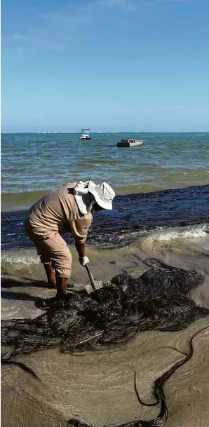  ?? Carlos Ezequiel Vannoni/Agência Pixel Press/Folhapress ?? Homem recolhe óleo na praia de Peroba, na cidade de Maragogi, em Alagoas, um dos nove estados afetados pelo vazamento; na quinta (17), o Ministério Público Federal entrou com uma ação contra a União por conta omissão no caso das manchas no Nordeste, que, segundo o órgão, é o maior desastre ambiental da história no litoral brasileiro em termos de extensão