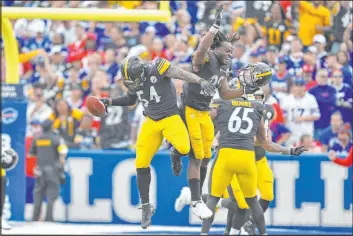  ?? Adrian Kraus The Associated Press ?? Pittsburgh Steelers linebacker Ulysees Gilbert (54) celebrates with teammates after returning a blocked punt for a touchdown against the Buffalo Bills on Sunday.