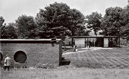  ?? Allyn Burns/The New York Times ?? Visitors touring the Glass House, at right, 105 feet from the Brick House, with porthole windows, at the estate of architect Philip Johnson in New Canaan, Conn., on May 23, 1965. Johnson completed them months apart in 1949.