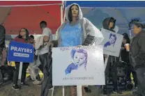  ?? Kin Man Hui / Staff photograph­er ?? Diana Contreras, center, holds a sign with the image of baby King Jay Davila.