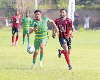  ?? PHOTO BY LENNOX ALDRED ?? Arnett Gardens’ goal-scorer Roderick Granville (right) is in a race for the ball with Vere United’s Odane Murray during their Jamaica Premier League encounter at Effortvill­e Community yesterday.