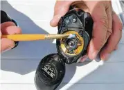  ?? Ralph Winingham ?? A good coating of grease lightly brushed onto the inside of a fishing reel used in saltwater angling will go a long way toward keeping the gear in good working order, according to veteran Guide Scott Hibbetts.