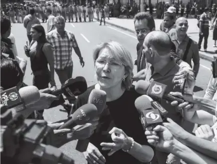  ?? Afp/getty Images ?? Venezuela’s chief prosecutor, Luisa Ortega Diaz, one of President Nicolas Maduro’s most vocal critics, speaks to the media during a visit Saturday to the public prosecutor’s office in Caracas as national guard units stand nearby.