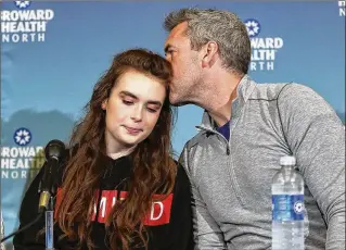  ?? JOE RAEDLE / GETTY IMAGES ?? David Wilford kisses his daughter, Maddy Wilford, after she spoke to the media about her recovery Monday at Broward Health North. “I’d just like to say that I’m so grateful to be here and it wouldn’t be possible without the doctors, officers and first...