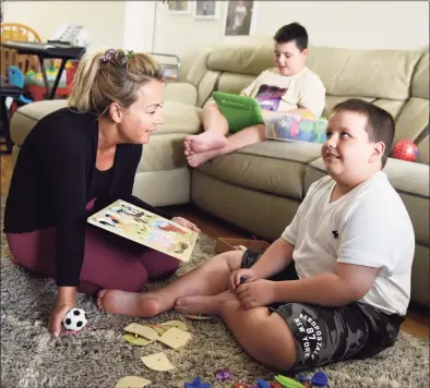  ?? Tyler Sizemore / Hearst Connecticu­t Media ?? Timea Zadori cares for her two children, Noah, center, 9, and Noel, right, 10, at her apartment in Greenwich last month. Zadori quit her job during the pandemic to care for her two nonverbal sons on the autism spectrum who require constant attention and assistance.