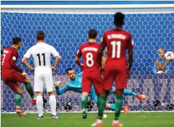  ?? (Reuters) ?? CRISTIANO RONALDO (left) scores Portugal’s first goal on a penalty in its 4-0 victory over New Zealand last night in Confederat­ions Cup action from Russia.