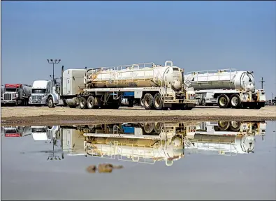  ?? Bloomberg News/CALLAGHAN O’HARE ?? Oil tanker trucks sit this summer at a truck stop in Pecos, Texas, in the Permian basin.