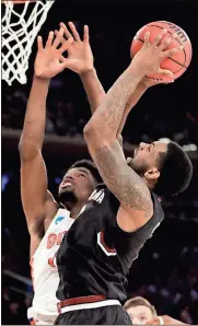  ?? Julio Cortez / The Associated Press ?? South Carolina guard Sindarius Thornwell (right) puts up a shot against Florida forward Kevarrius Hayes during the second half of Sunday’s East Regional championsh­ip game.