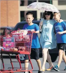  ?? ALLEN McINNIS ?? Sun Chen and sons, Max, right, and Alex shop for groceries Thursday as the temperatur­es hit 34 C with a humidex value of 43 C.