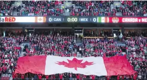  ?? DARRYL DYCK / THE CANADIAN PRESS FILES ?? A large Canadian flag is held up by fans before Canada and Mexico play a FIFA World Cup qualifying soccer match in Vancouver in 2016.