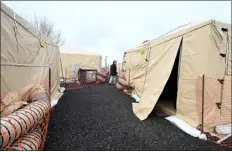  ?? ?? Loveland City Councilor Steve Olson walks around the new heated tents that were set up to house the unhoused Wednesday while touring the new homeless shelter on south Railroad Avenue in Loveland.