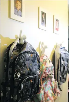  ?? JULIE OLIVER ?? Backpacks hang on funky hooks beside the nook with kids’ pictures above in Kristi Blok’s home.