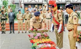  ??  ?? PTI Senior police officers pay floral tribute to head constable Habibullah during a wreath-laying ceremony at the District Police Lines in Srinagar on Friday.