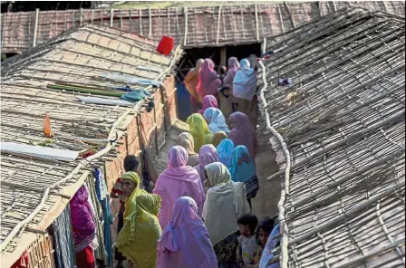  ?? — AFP ?? Safe haven: Women walking inside the widow’s camp in Bangladesh’s Ukhia district.