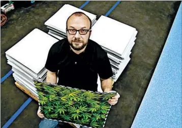  ?? VERNON BRYANT/THE DALLAS MORNING NEWS ?? Keith Pocock, manager of operations at Grow Life Innovation­s, developed a reflective tile that helps plants grow indoors.