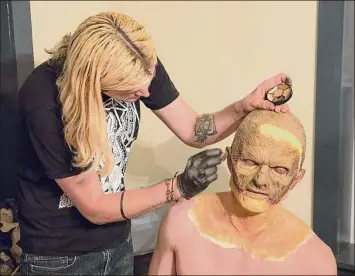  ?? ?? Above, a makeup artist works on the look for Michael Wetherbee’s Creature character for “The Last Frankenste­in.” Left, filming a scene from the movie while in Amsterdam.