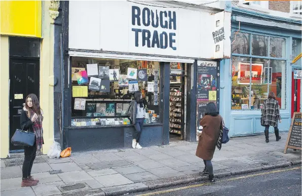  ?? PHOTOS: JONATHAN ELDERFIELD ?? Tourists take photos outside the Rough Trade record shop in London. Rough Trade opened in 1976 on Kensington Park Road. Today, it’s located on Talbot Road, filled with vinyl and CDs, its walls and ceiling adorned with posters featuring The Clash and...