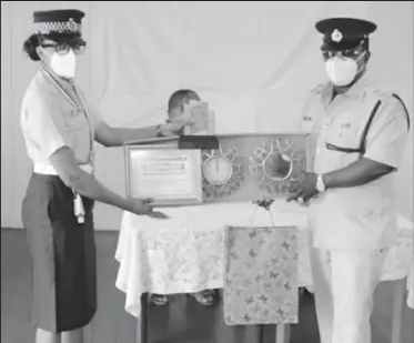  ??  ?? Constable Persaud receiving her awards from Officer-In-Charge of Traffic in Region Six Assistant Superinten­dent of Police Raun Clarke last month