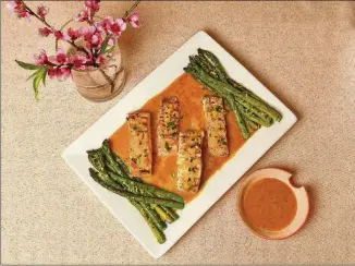  ?? STYLING BY AUBREY LENYARD / CHRIS HUNT FOR THE AJC ?? Grilled Pineapple Mango Halibut is served with Fiery Pineapple Mango Aubsauce, which gets its heat from serrano peppers.