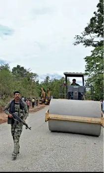  ??  ?? TURF WAR Security personnel guard a road constructi­on team in Dantewada in 2016