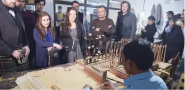  ?? Agence France-presse ?? Internatio­nal musicians watch the process to make bagpipes at the Mid East bagpipe factory in Sialkot.