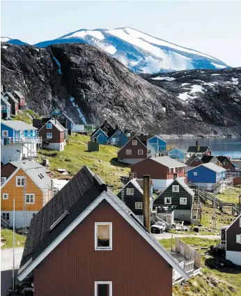  ?? PHOTO D’ARCHIVES, AFP ?? Institutio­nnellement rattachée au Danemark, la gigantesqu­e île, située en Arctique, abrite environ 56 000 habitants. Sur la photo, la petite ville d’upernavik.