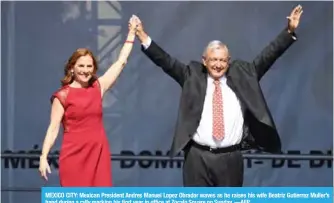  ??  ?? MEXICO CITY: Mexican President Andres Manuel Lopez Obrador waves as he raises his wife Beatriz Gutierrez Muller’s hand during a rally marking his first year in office at Zocalo Square on Sunday. —AFP