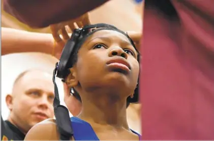  ?? LLOYD FOX/BALTIMORE SUN PHOTOS ?? Azziz Grooms has his headgear secured as he gets ready for his wrestling match at the City Championsh­ips.