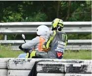  ?? CRASH ?? SUDAH MENYERAH: Valentino Rossi dievakuasi oleh kru MotoGP setelah mengalami kecelakaan di GP Catalunya Minggu lalu (27/9).