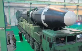 ??  ?? North Korea released images of North Korean leader Kim Jong Un ( right) inspecting the missile with officials.