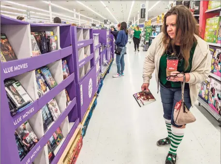  ?? Tribune News Service ?? Heather Peeples shops for deals on DVDs at Walmart during Black Friday last year. Walmart won’t be open on Thanksgivi­ng this year and said it will spread its Black Friday deals out across the season.