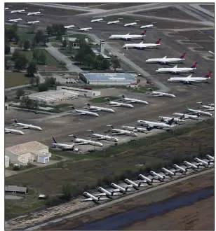  ?? (Arkansas Democrat-Gazette/Thomas Metthe) ?? Delta Airlines jets sit on the tarmac Thursday at Arkansas Internatio­nal Airport in Blythevill­e. Aviation Repair Technologi­es, based at the airport, has accepted 77 aircraft since March 17. All have been idled because of a global slowdown in commercial air traffic related to the pandemic.