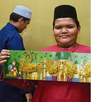  ??  ?? Mohamad danial’s task is to put up Hari raya decoration­s.