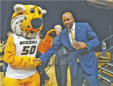  ?? THE ASSOCIATED PRESS ?? Cuonzo Martin shakes hands with the Missouri mascot, Truman the Tiger, after being formally introduced as the new head basketball coach at the university on March 20 in Columbia, Mo. Martin spent the past three seasons at California.