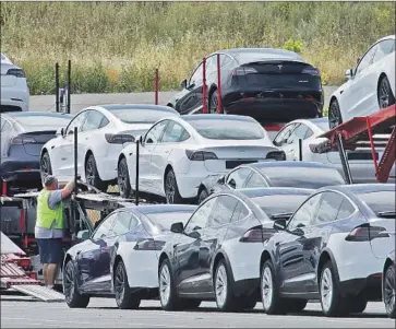  ?? CALIFORNIA’S Ben Margot Associated Press ?? electrical capacity today would not be sufficient to power the deluge of expected EV cars and light trucks by 2035 without considerab­le work, some say. Above, Tesla cars are loaded in Fremont in May.