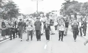  ?? — Gambar Roystein Emmor ?? KE PENGERAI: Dr Abdul Rahman (tiga kiba) enggau Hilmy (dua kiba) nyereta raban bejalai kaki maya Program Kuching Car Free Morning.