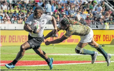  ?? Picture: RODGER BOSCH / AFP ?? OUT OF REACH: Fiji’s Waisea Nacuqu, left, leaves SA’s Justin Geduld clutching air as he scores at the Cape Town Stadium last Sunday.