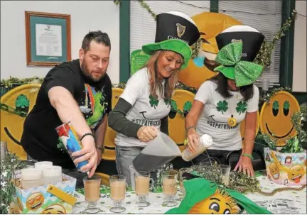  ?? GENE WALSH ― DIGITAL FIRST MEDIA ?? Bridgeport Rib House team members, from left, Chris Antenucci, Melissa Navitsky, and Andee Krick fill their glasses during the 12th Annual Ancient Order of Hibernians Notre Dame Division 1 Montgomery County Irish Coffee Contest in Swedesburg.