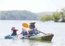  ?? STAFF PHOTO BY ERIN O. SMITH ?? Jonathan Prater pulls his two sons, Branch Prater, 3, and Knox Prater, 5, as he kayaks toward the shore July 5 at Chester Frost Park in Hixson.