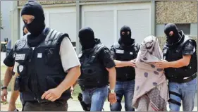  ?? REUTERS ?? French special police forces escort a woman from a residentia­l building during a raid in SaintPries­t, near Lyon, France, on Friday.