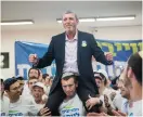  ?? (Yonatan Sindel/Flash90) ?? RAFI PERETZ, leader of Bayit Yehudi, dances with Union of Right-Wing Parties activists during a visit to the party’s situation room in Jerusalem yesterday.